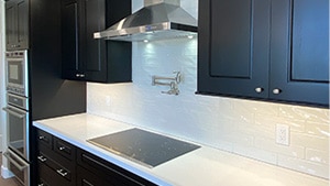 Modern Cooktop on White Countertop and Dark Cupboard view